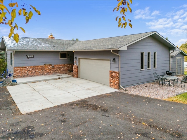 view of front of home featuring a garage and a patio