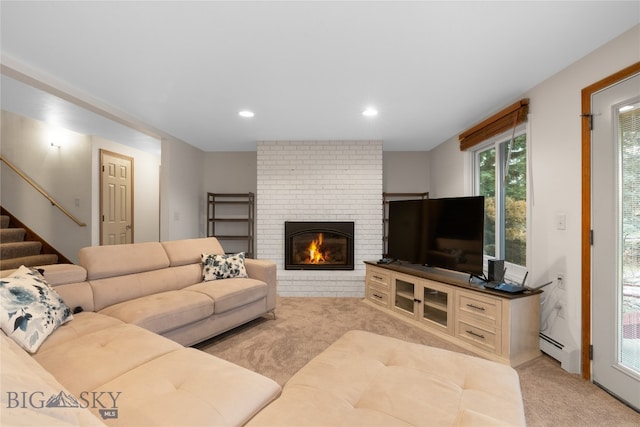 living room featuring a baseboard heating unit, light carpet, and a brick fireplace