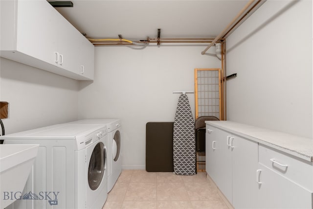 laundry area featuring cabinets, light tile patterned floors, separate washer and dryer, and sink