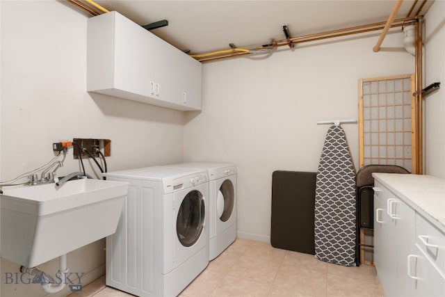 laundry area with washing machine and dryer, sink, light tile patterned flooring, and cabinets