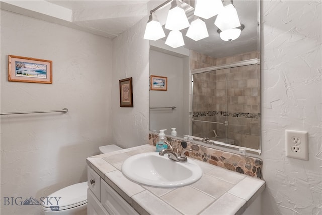 bathroom featuring vanity, toilet, and an enclosed shower