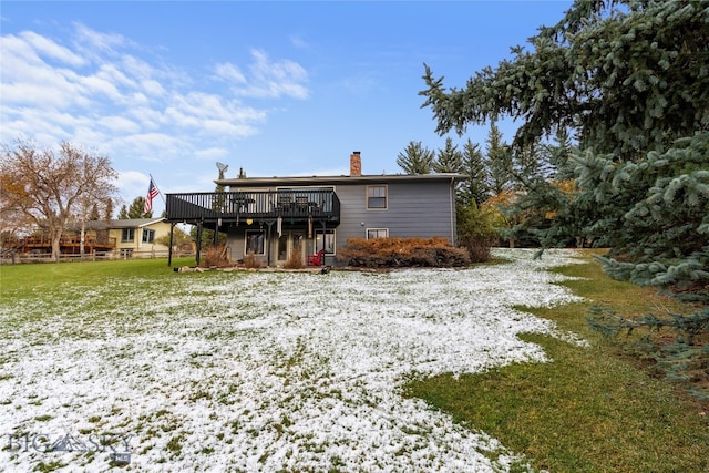 rear view of property featuring a lawn and a deck