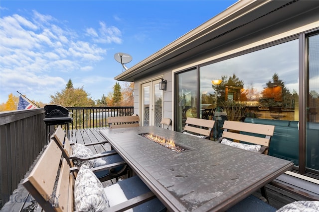 wooden deck with area for grilling and an outdoor fire pit