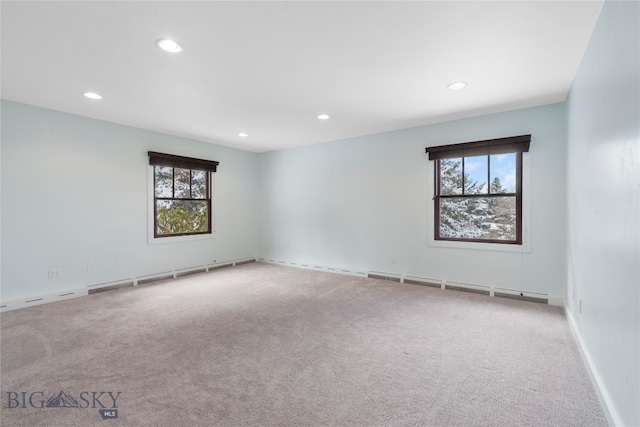 spare room with carpet flooring, baseboard heating, and plenty of natural light