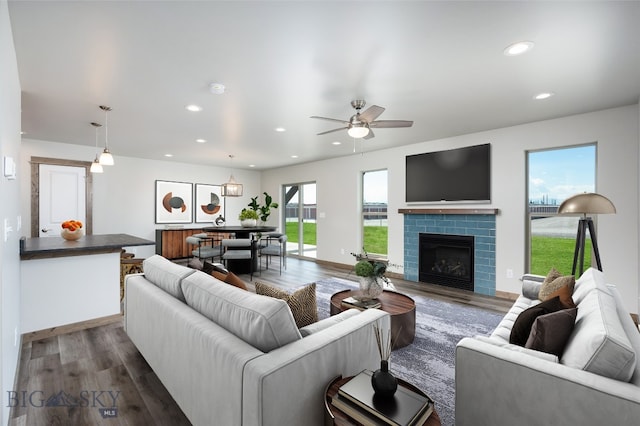 living room with a fireplace, dark hardwood / wood-style flooring, and ceiling fan