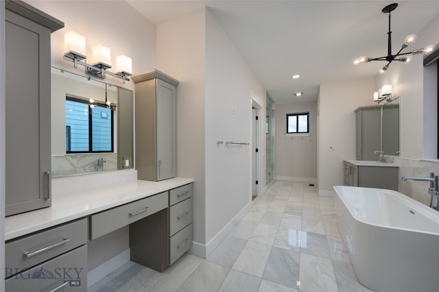 bathroom with vanity, independent shower and bath, and a notable chandelier