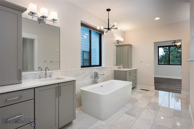 bathroom featuring a bathing tub, vanity, and an inviting chandelier