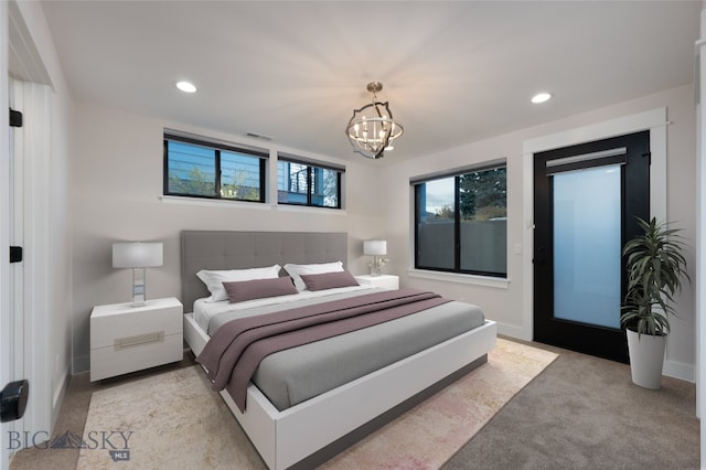 carpeted bedroom with an inviting chandelier