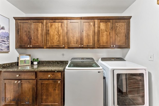 clothes washing area with cabinets and washer and clothes dryer