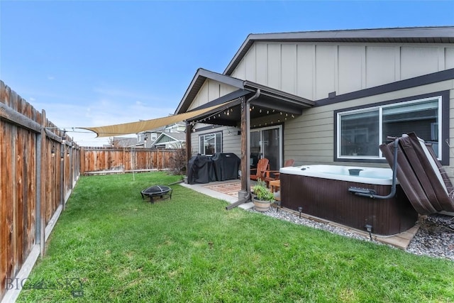 view of yard with a patio area, a hot tub, and an outdoor fire pit