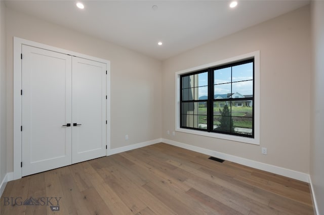 unfurnished bedroom with light wood-type flooring and a closet