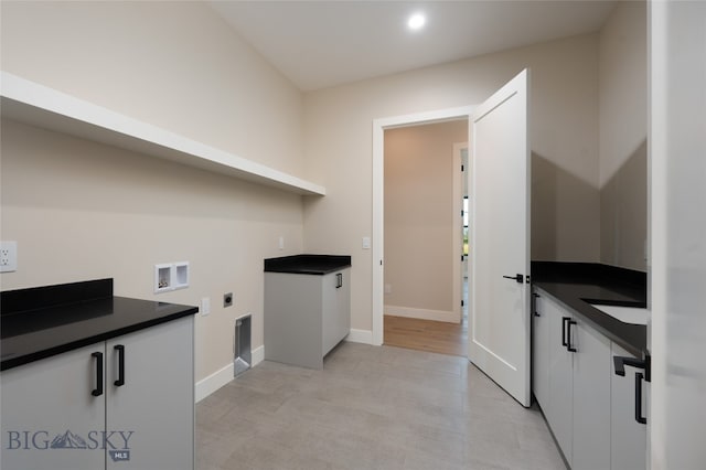 washroom with cabinets, hookup for a washing machine, and electric dryer hookup