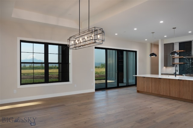 kitchen with a mountain view, light hardwood / wood-style floors, and hanging light fixtures