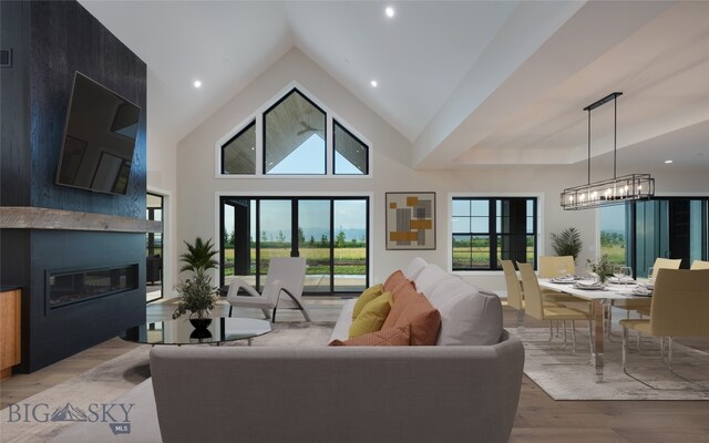 living room featuring a fireplace, high vaulted ceiling, and light wood-type flooring