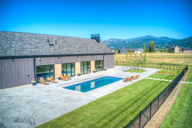 view of pool with a lawn, a mountain view, and a patio