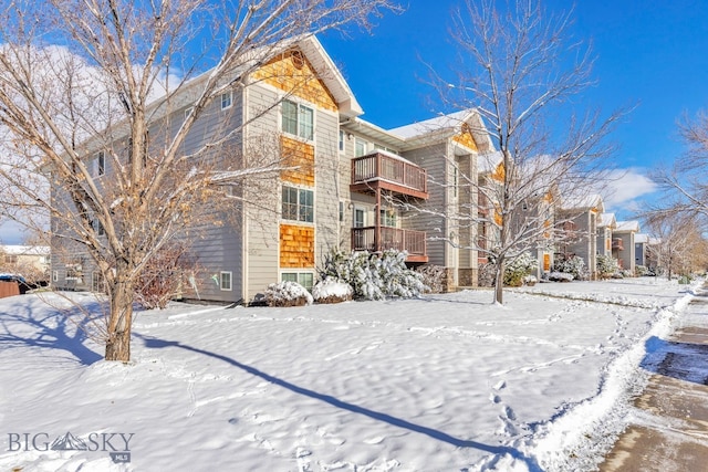 snow covered property with a balcony