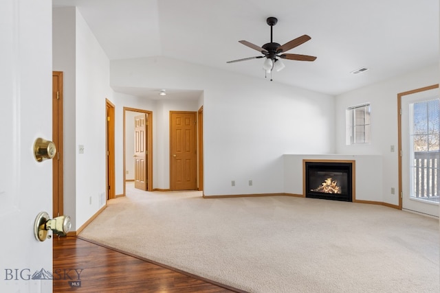 unfurnished living room with carpet flooring, ceiling fan, and vaulted ceiling