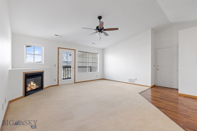 unfurnished living room featuring ceiling fan, hardwood / wood-style floors, and lofted ceiling