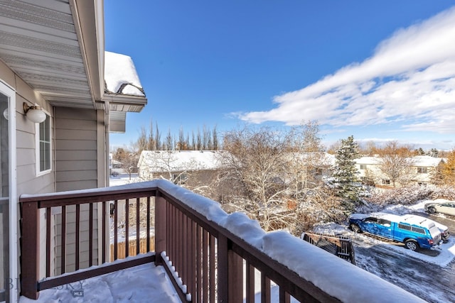 view of snow covered back of property