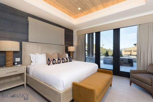 carpeted bedroom featuring access to outside, a tray ceiling, and wood ceiling