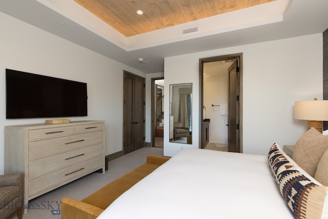 bedroom with a tray ceiling, light colored carpet, and wooden ceiling