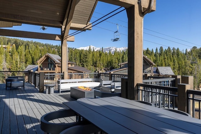 117 Martingale Frk Unit 6, Big Sky, MT 59716 - wooden deck with a forest view, a fire pit, and outdoor dining area