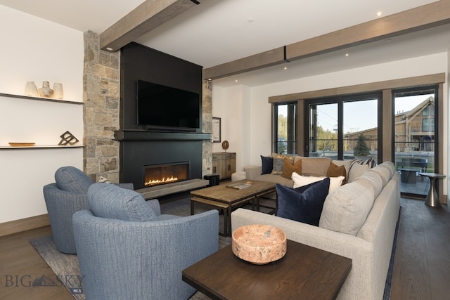 living room featuring beam ceiling, dark hardwood / wood-style flooring, and a stone fireplace