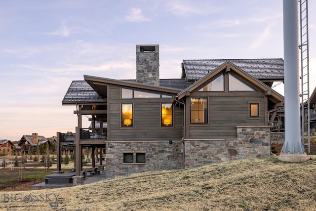 117 Martingale Frk Unit 6, Big Sky, MT 59716 - view of side of property with stone siding, a chimney, a balcony, and a patio area