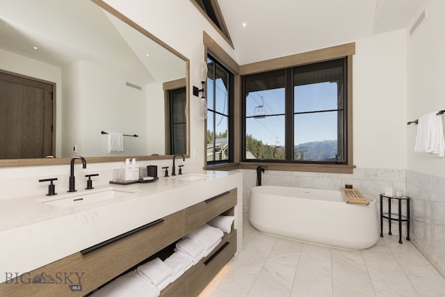 bathroom with a washtub, vanity, tile walls, and lofted ceiling