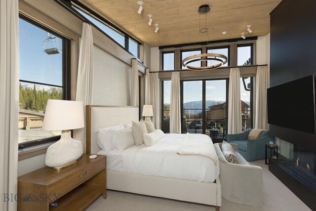 117 Martingale Frk Unit 6, Big Sky, MT 59716 - carpeted bedroom featuring wooden ceiling and multiple windows