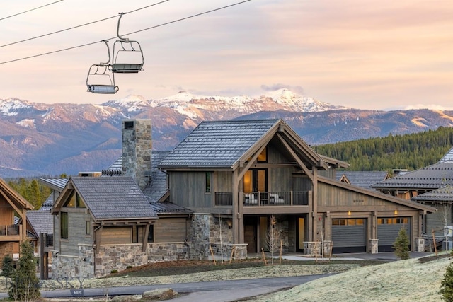 117 Martingale Frk Unit 6, Big Sky, MT 59716 - view of front facade with stone siding, a balcony, a mountain view, and a chimney
