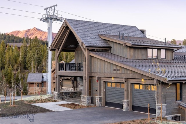 117 Martingale Frk Unit 6, Big Sky, MT 59716 - view of front of house featuring driveway, a mountain view, metal roof, a balcony, and stone siding