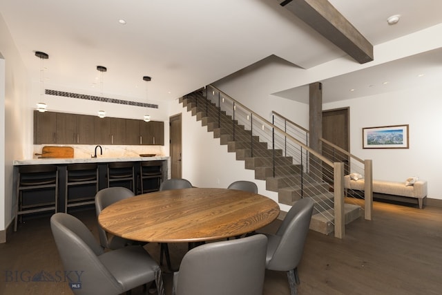 dining space featuring sink, beamed ceiling, and dark hardwood / wood-style floors