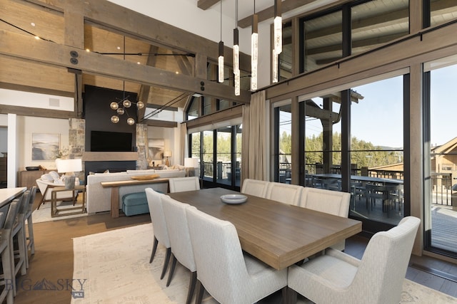 dining area featuring beam ceiling, high vaulted ceiling, a chandelier, and hardwood / wood-style flooring