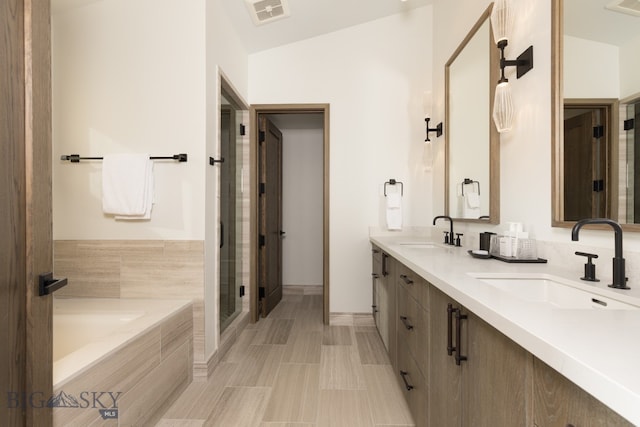 bathroom featuring plus walk in shower, tile patterned flooring, vanity, and vaulted ceiling