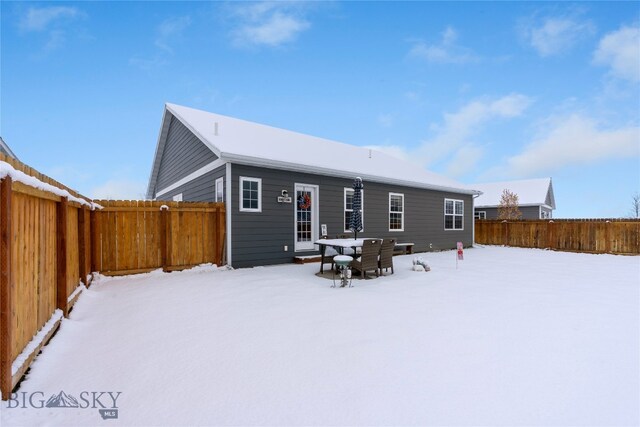 view of snow covered back of property