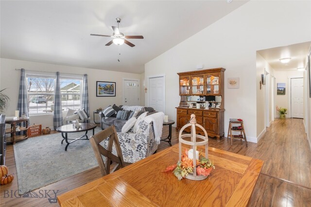 dining room featuring hardwood / wood-style flooring, ceiling fan, and high vaulted ceiling