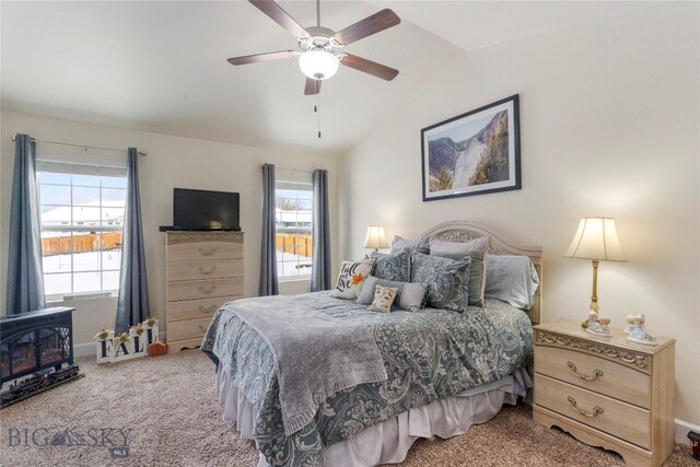 carpeted bedroom featuring a wood stove, ceiling fan, and lofted ceiling