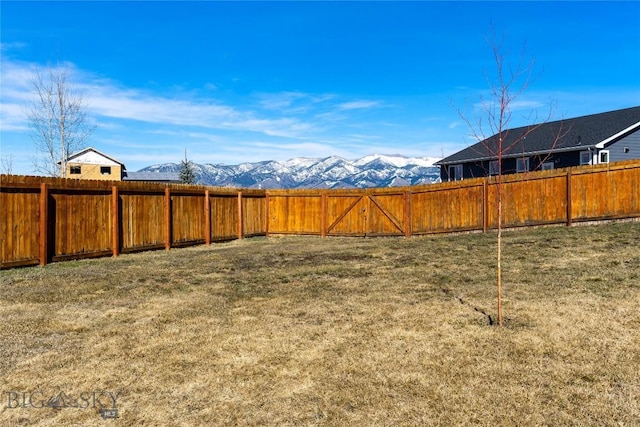 view of yard with a fenced backyard and a mountain view