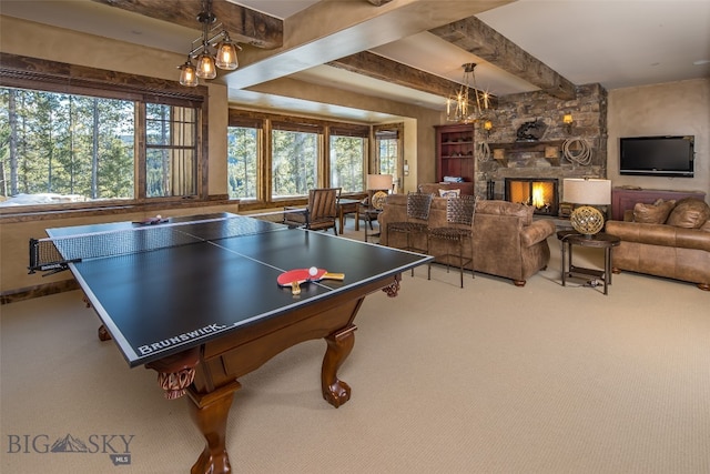 playroom with beam ceiling, a stone fireplace, and carpet floors