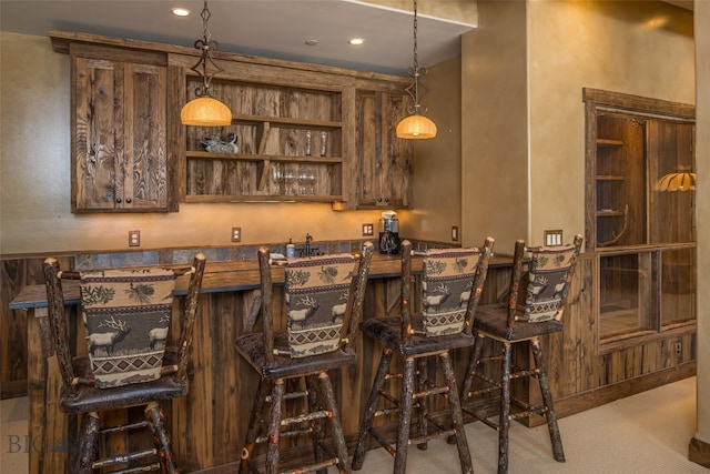 bar featuring carpet floors and pendant lighting