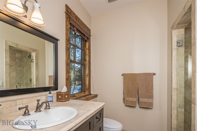 bathroom with vanity, tasteful backsplash, toilet, and an enclosed shower