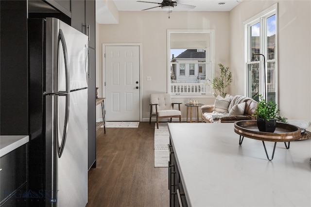 kitchen featuring dark hardwood / wood-style floors, stainless steel refrigerator, and ceiling fan