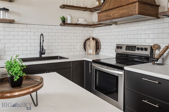 kitchen with tasteful backsplash, sink, stainless steel range with electric cooktop, and premium range hood