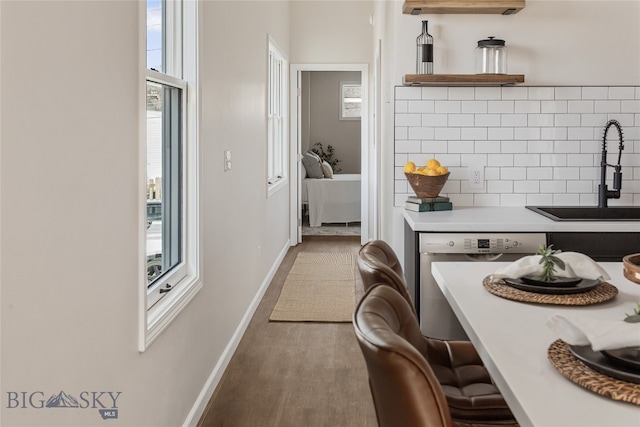 kitchen with decorative backsplash, hardwood / wood-style flooring, a wealth of natural light, and sink