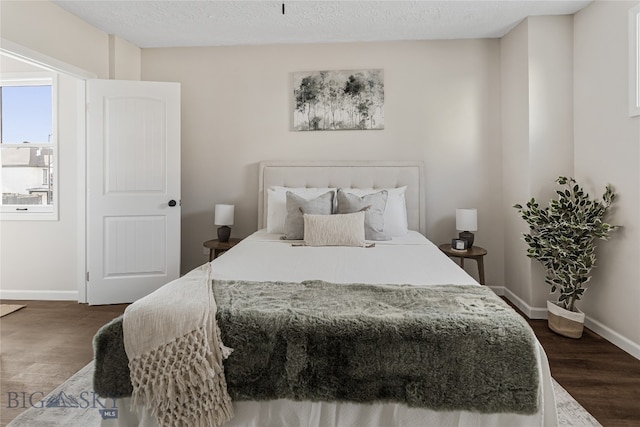 bedroom with dark hardwood / wood-style flooring and a textured ceiling