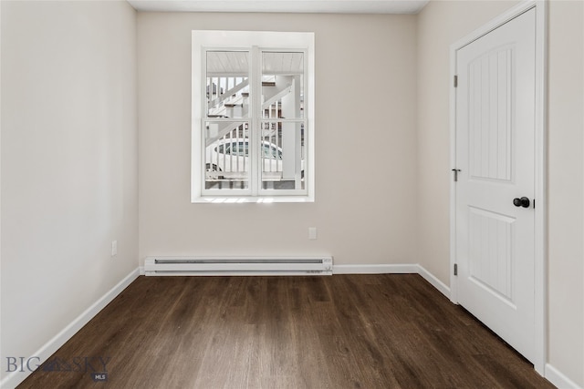 spare room with dark hardwood / wood-style floors and baseboard heating