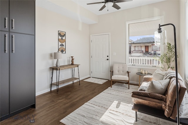 living area featuring ceiling fan and dark wood-type flooring