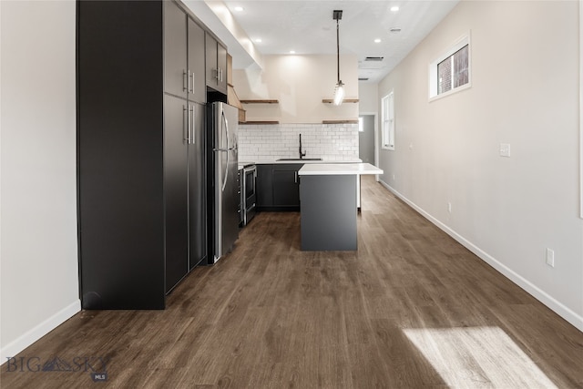 kitchen with sink, hanging light fixtures, tasteful backsplash, a kitchen island, and stainless steel appliances