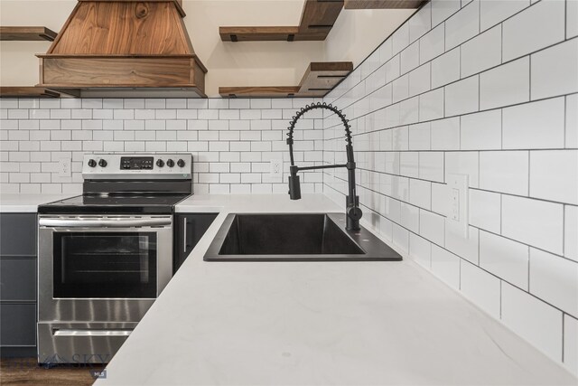 kitchen featuring sink, dark hardwood / wood-style floors, backsplash, stainless steel electric range, and custom exhaust hood